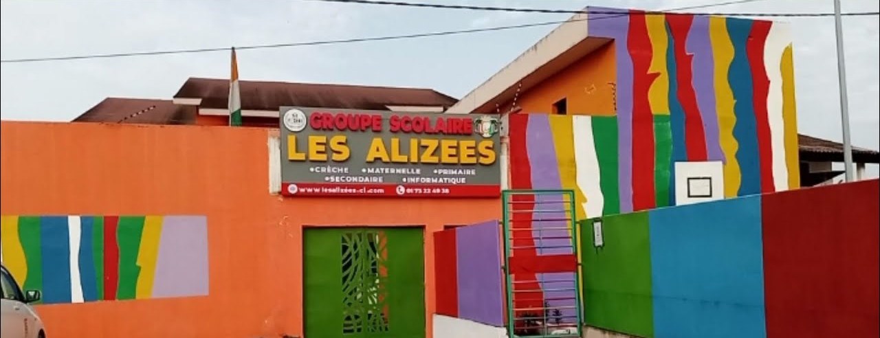 Façade aux bandes colorées et enseigne du Groupe Scolaire Les Alizées